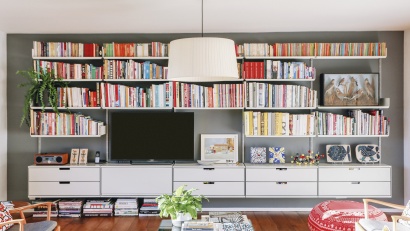 TV stand and library bookshelves, sideboard cabinets with drawers for storage in the living room. Wall mounted, off-white. Vitsœ Modular 606 Universal Shelving System. Designer shelves, Dieter Rams