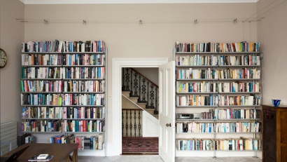 Large wall-mounted bookshelves, 2 white metal bookcases. Custom solutions for book storage. Designer shelves, Dieter Rams. Vitsœ 606 Universal Modular Shelving System.