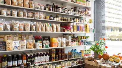 Shop display shelving, wall mounted, metal, off-white. Organic grocery store. Modular Vitsœ 606 Universal Shelving System. Design Dieter Rams