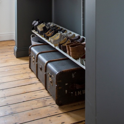 Custom made alcove open wardrobe system with shoe storage. Sloping shelves in off-white. Vitsœ 606 Shelving system, designer Dieter Rams.