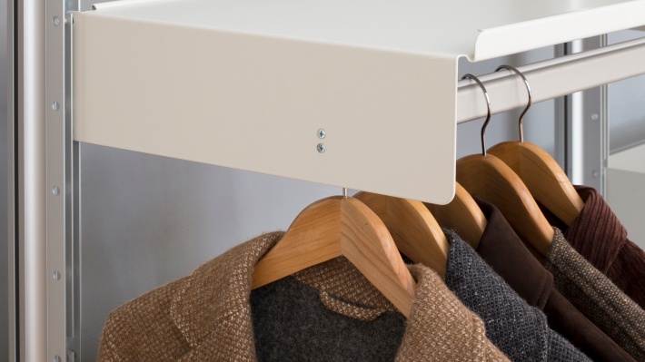 Strong hanging rail shelf for heavy clothes, Wall mounted wardrobe shelving. Modern off-white. Vitsœ modular 606 Shelving system, designer Dieter Rams.