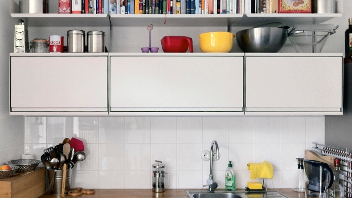 Cabinets and shelves above kitchen sink for kitchenware. Modular shelving system, strong metal, wall mounted. Vitsœ 606.